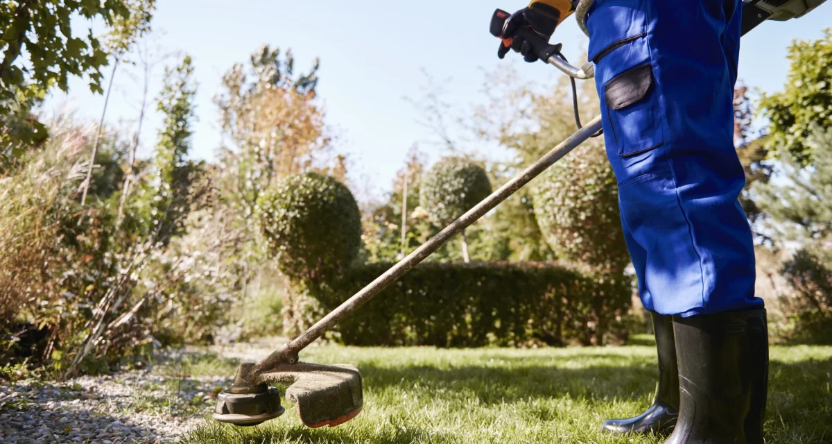 gartner-mit-unkrautvernichter-beim-rasenmahen-im-garten